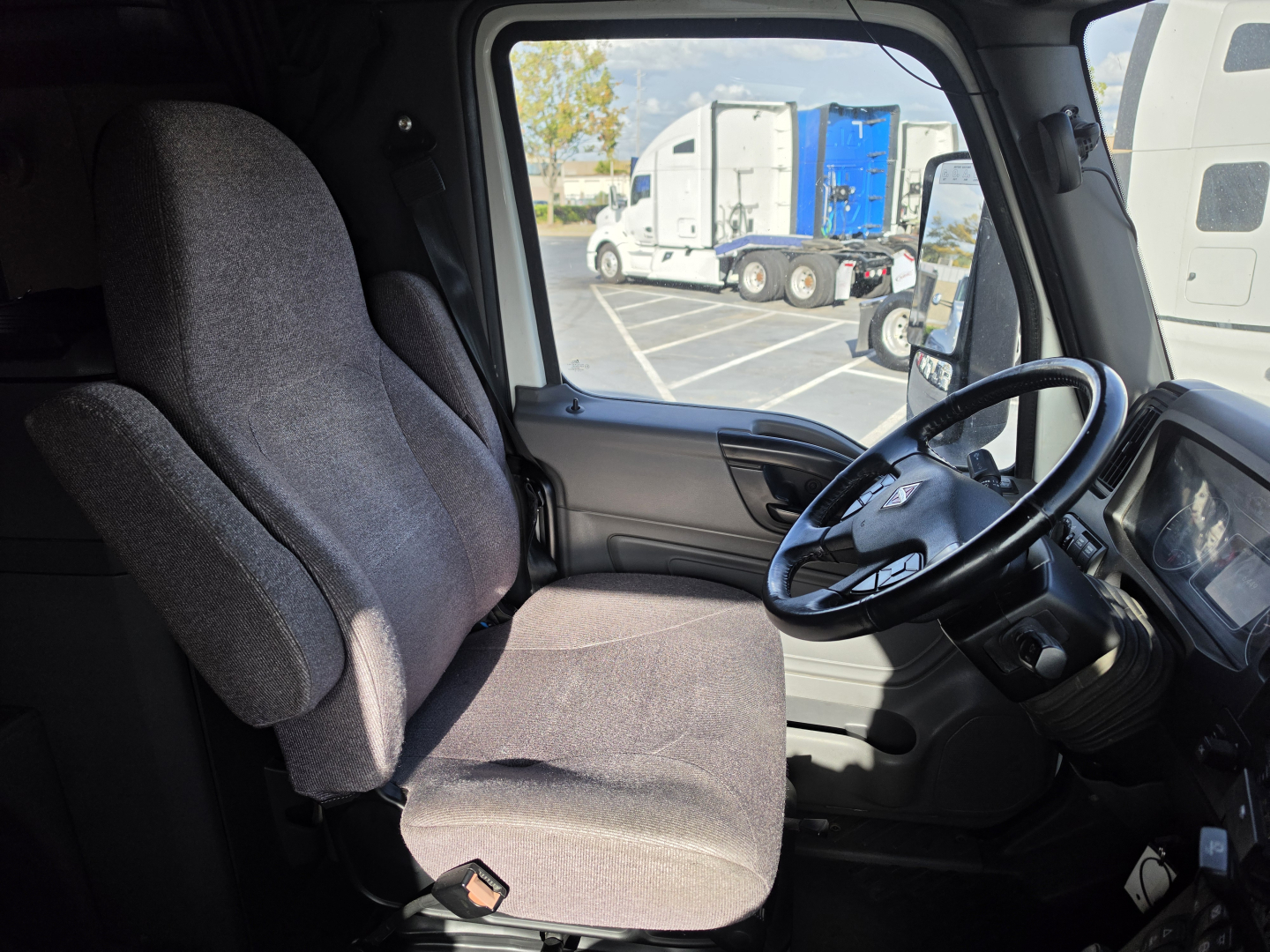 Interior of a 2023 International LT625 truck cab showing driver seat and steering wheel.