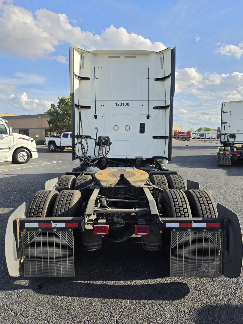 Tractor rear view showing fifth-wheel and dual rear axles with mudguards and high-visibility reflectors.