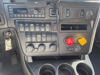 Dashboard panel of a 2023 International LT625 truck showing control switches, climate knobs, radio display, and emergency/drive controls.