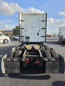 Tractor rear view showing fifth-wheel and dual rear axles with mudguards and high-visibility reflectors.
