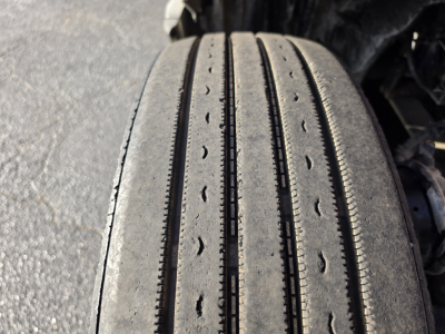 Tire tread close-up on International LT625 truck showing multiple grooves and wear patterns.
