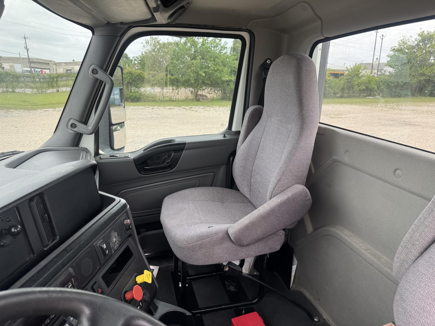 Cab interior of a 2021 International LT truck showing the driver's seat, dashboard controls, steering wheel, and passenger area.