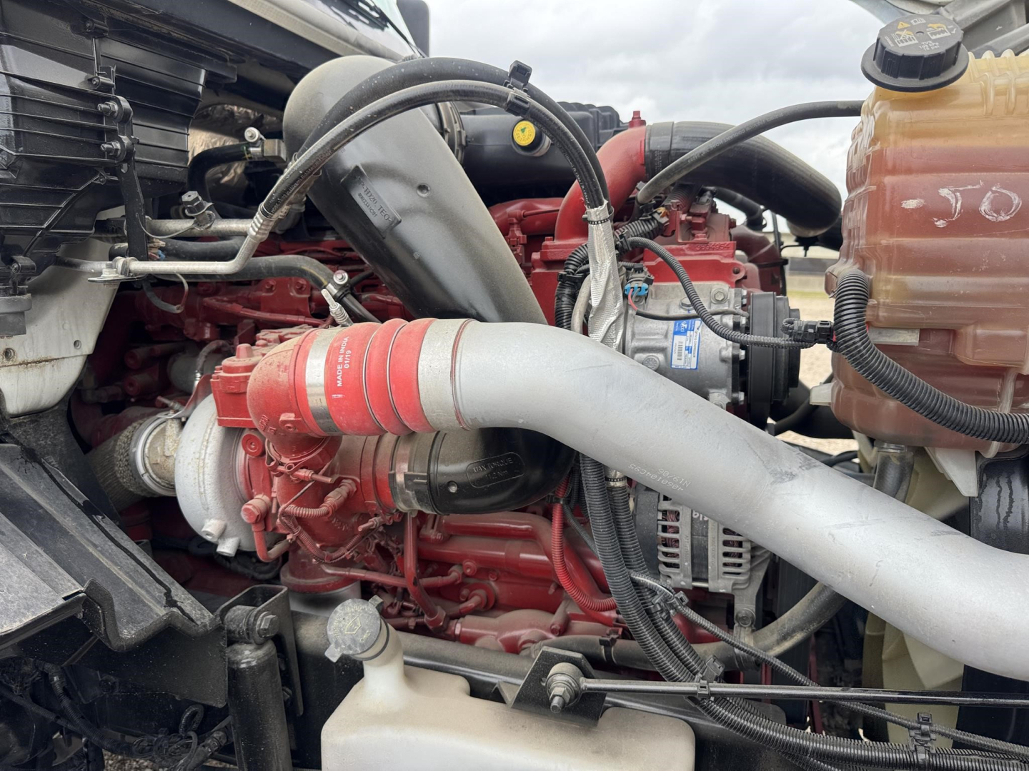 International LT engine bay showing turbocharger intake piping and coolant reservoir.