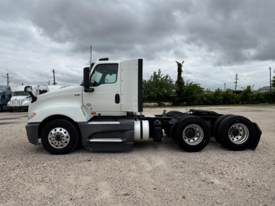 Tractor truck side view showing two rear axles, white cab, fuel tank, and chassis for a 2021 International LT Conventional Daycab. Visible text: none readable.