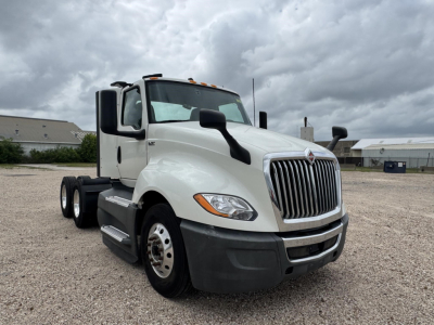 International LT conventional daycab truck with white cab, front grille, headlights, large side mirrors, dual rear axles, and stock number not visible on the body.