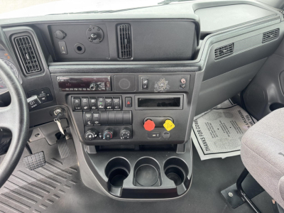 Dashboard view of a 2021 International LT truck cab showing instrument cluster, climate controls, switch panel, and cup holders.