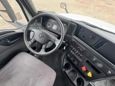 Interior of a 2021 International LT truck cabin showing steering wheel, dashboard, gear shifter, and center console with control buttons.