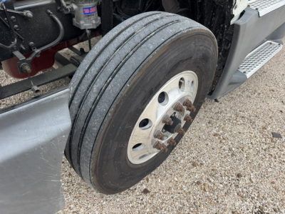 Truck wheel and front suspension of a 2021 International LT conventional daycab showing heavy-duty dual rear tires, hub, and step platform.
