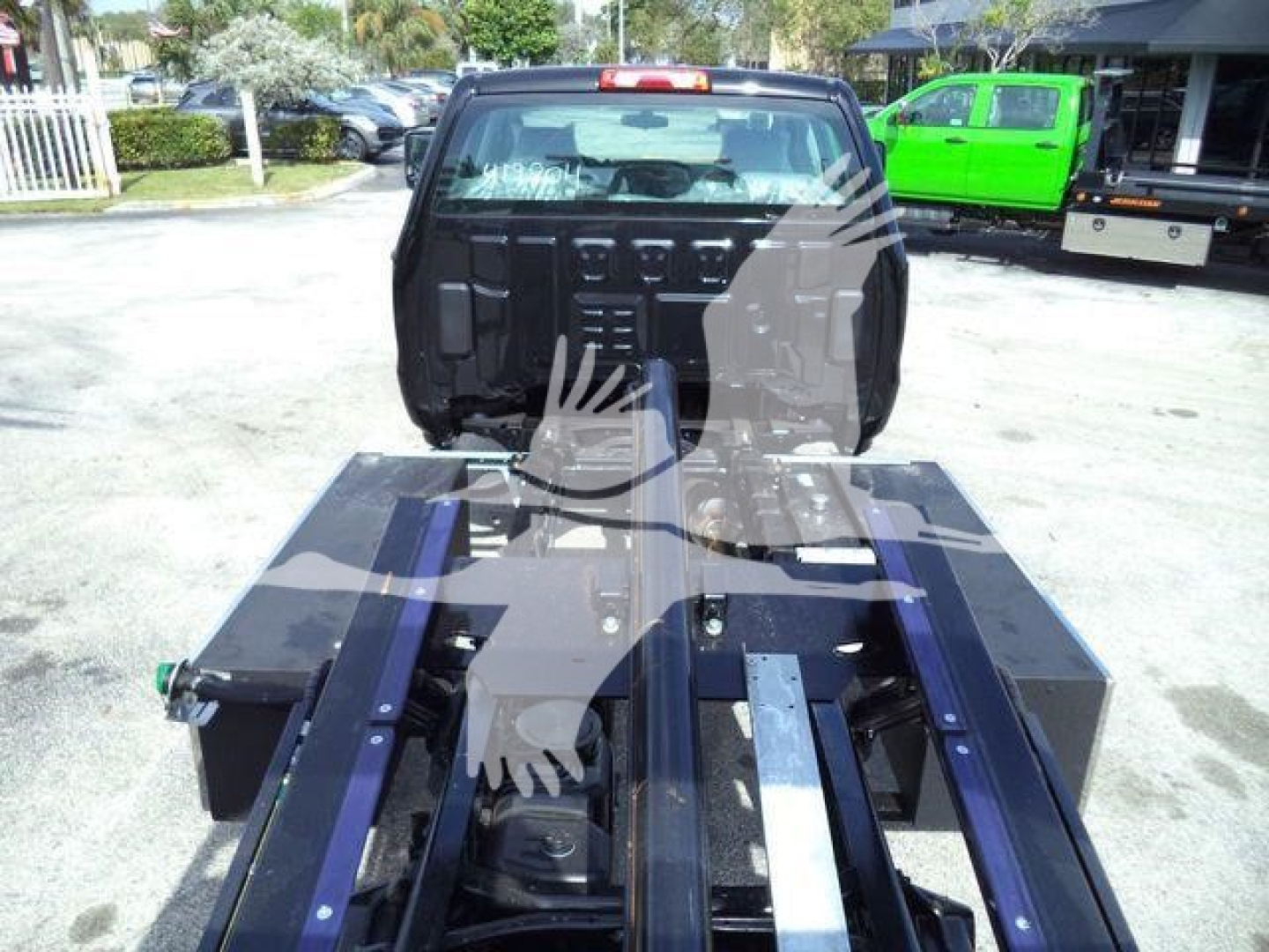 Truck chassis and cab area of a 2023 International CV rollback truck, view of the rear with the towing frame and storage boxes visible.