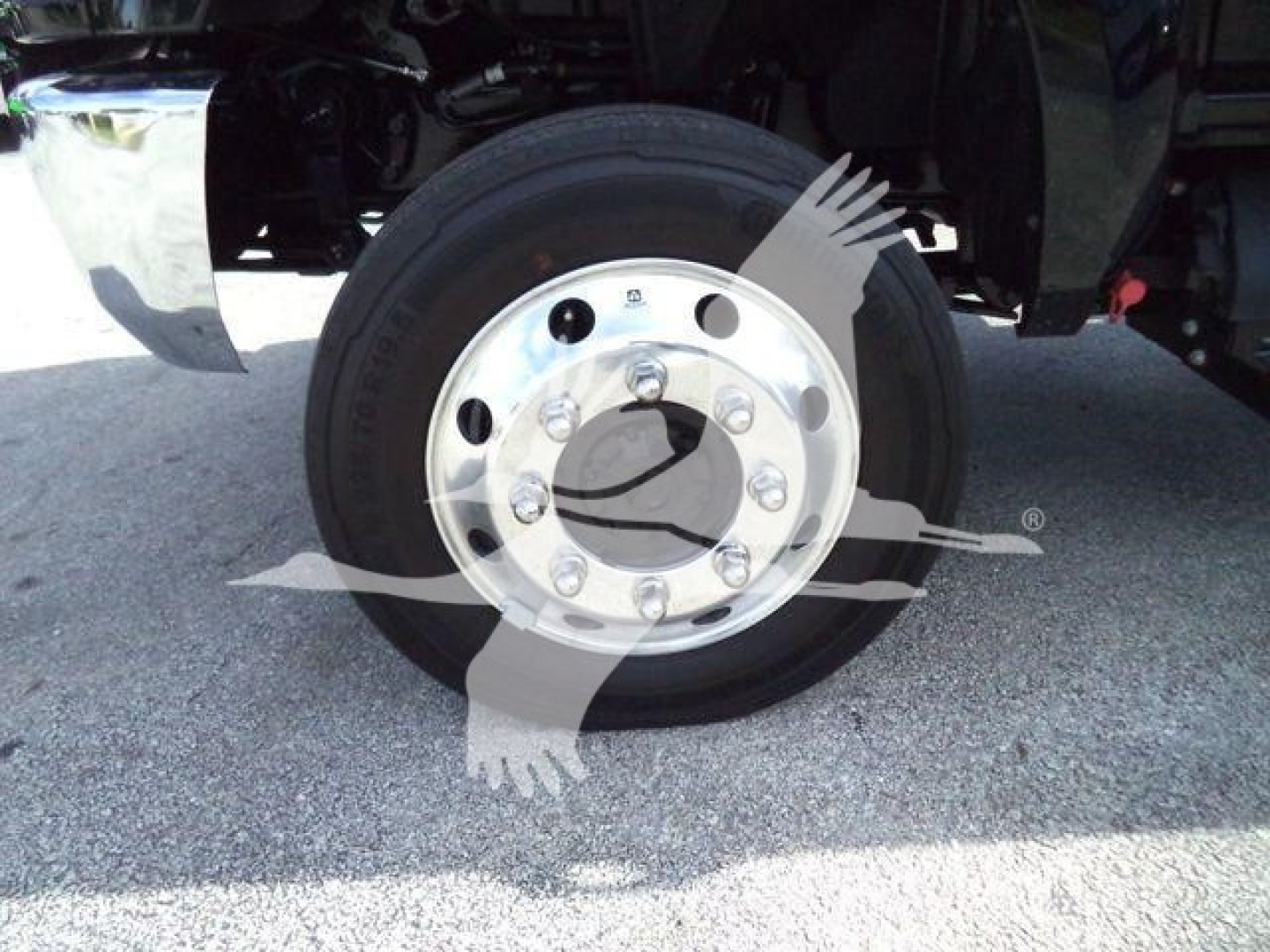 Truck wheel and hub showing chrome rim with multiple lug nuts on a CV rollback truck.