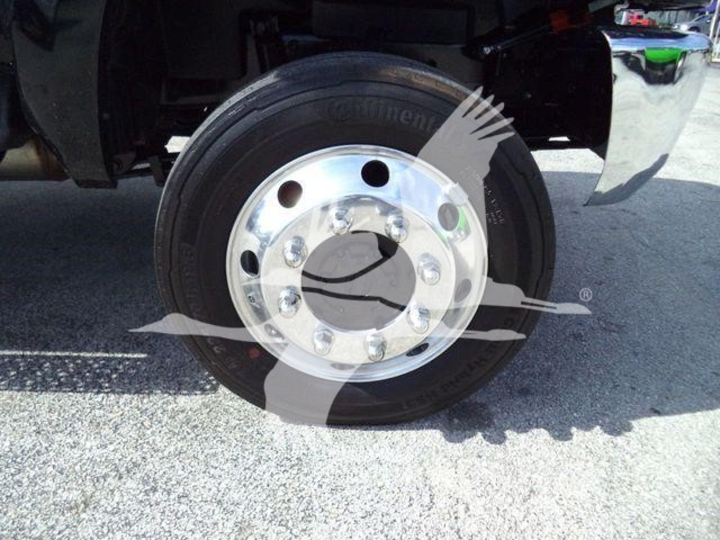 Truck wheel and tire close-up with hub and fender visible.
