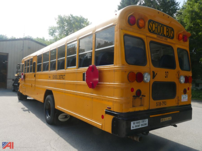Yellow school bus rear view with 'SCHOOL BUS' sign on top rear window and bus number 37, blue bird branding, standard school bus tail lights, in-service exterior.