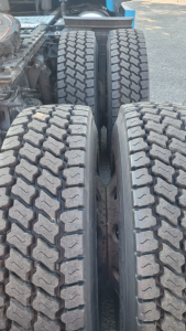 Truck rear twin-drive axle and tires showing tread pattern and sidewalls in a Freightliner Cascadia 126 tractor.