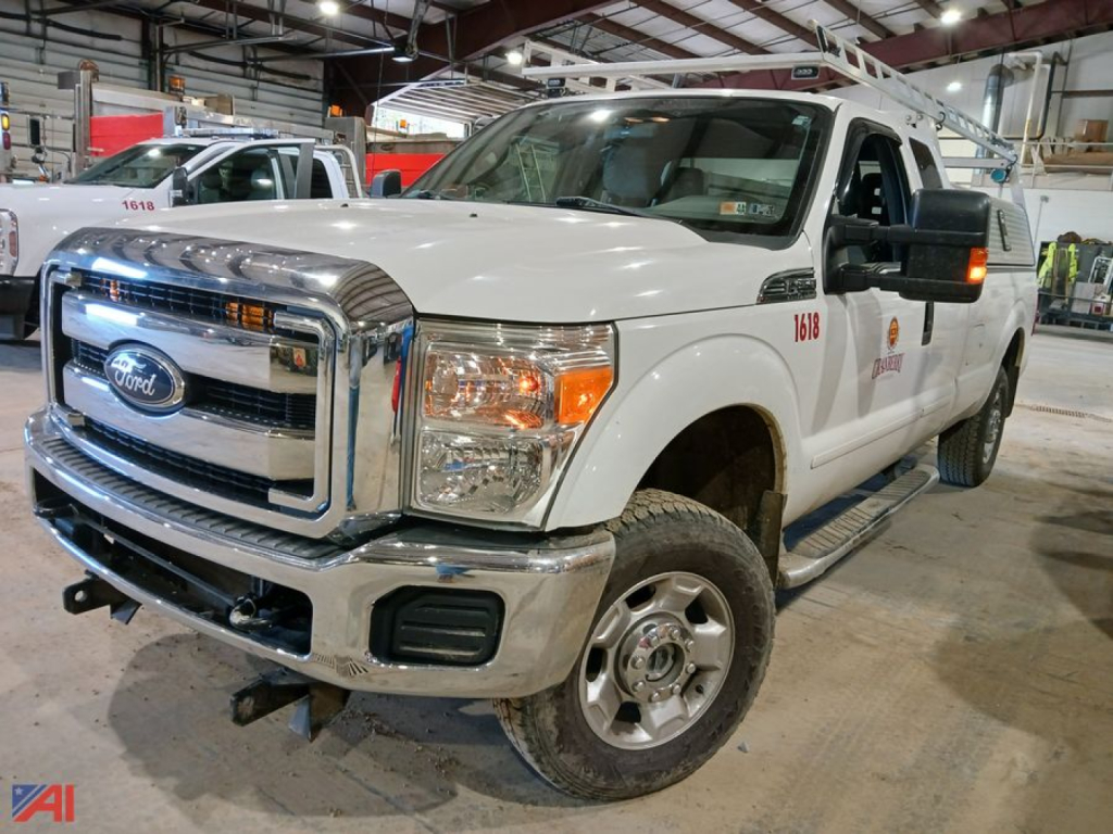Ford F-250 pickup truck in a warehouse, white Extended Cab with chrome grille, front bumper, and utility body equipment; 4x4 emblem visible.