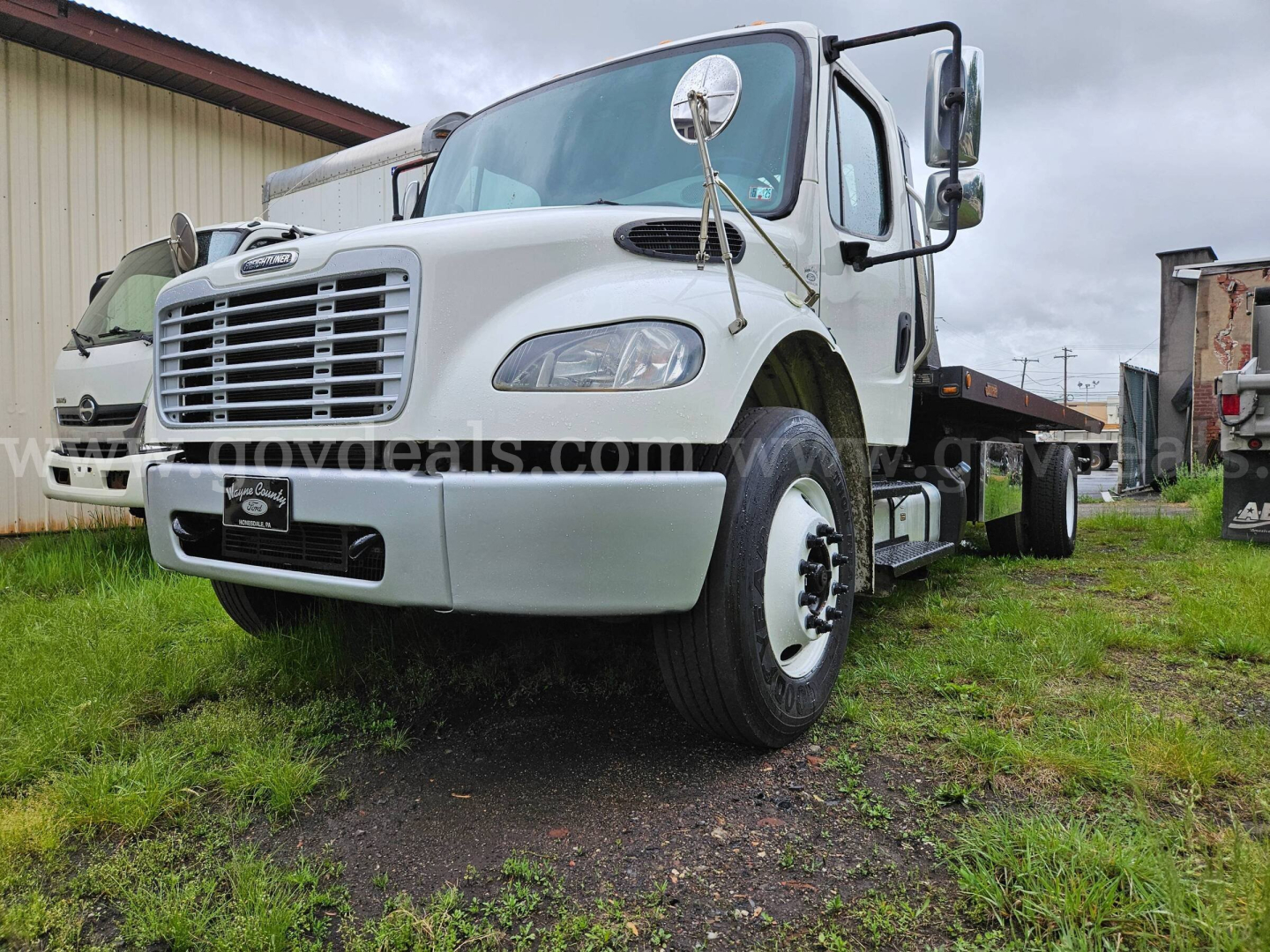 Truck cab and chassis of a 2015 Freightliner M2 106 tow truck showing front grille and wheel, VIN 3ALACXDT5FDGR5768 visible.