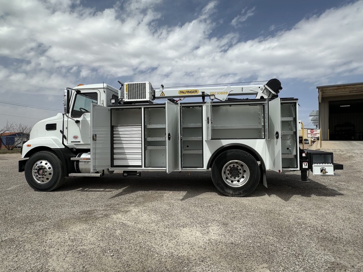 Service/utility truck side view showing multiple tool compartments and ladder rack on a Mack MD7 chassis.