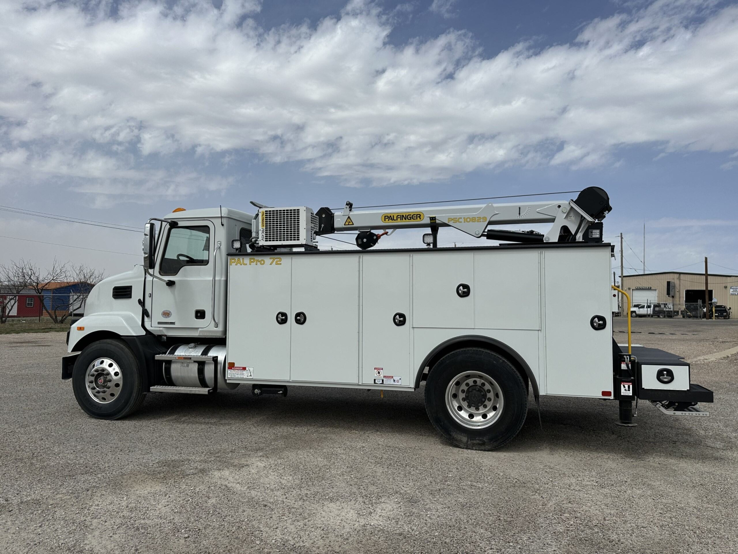 Mack MD7 service truck side view showing utility body with compartments and Boom Pro 76 crane.