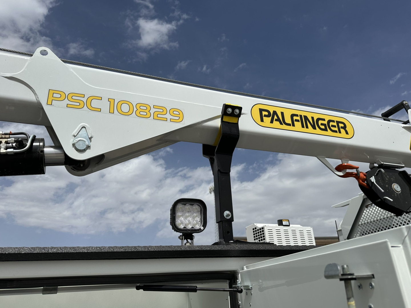 Palfinger crane arm with PSC 10829 markings and a small square LED work light in the foreground.
