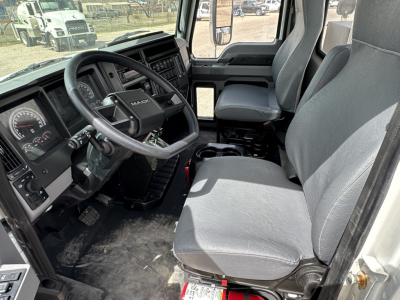 Cab interior of a 2025 Mack MD7 showing steering wheel, driver and passenger seats, dashboard with gauges, and center console.