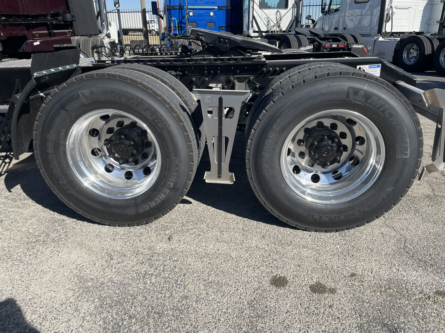 Volvo VNL64T860 axle area showing dual rear axle wheels and chrome rims with hub covers.