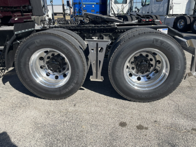 Volvo VNL64T860 axle area showing dual rear axle wheels and chrome rims with hub covers.