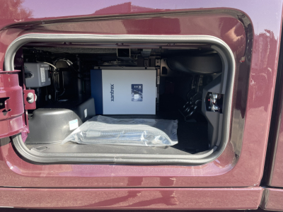 Volvo VNL64T860 engine bay section showing a boxed Xantrex device and wiring under the cab access panel.
