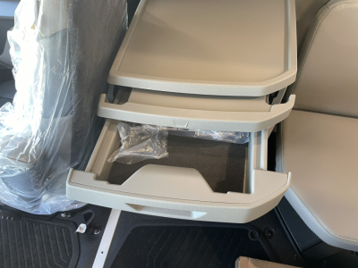 Cabin interior storage drawer open showing multiple trays and a lower bin in a Volvo VNL sleeper cab.