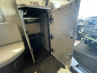 Vehicle interior showing an open storage cabinet in the cab area of a Volvo truck.