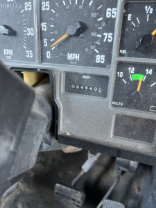 Dashboard of a 2000 International Navistar 3800 showing speedometer with MPH scale, odometer reading 064960, fuel gauge, and other gauges.