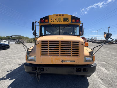 Front view of a yellow school bus with 'SCHOOL BUS' sign on top, International/Navistar 3800 model, rectangular headlights, black bumper, and chain hanging from the front grille.