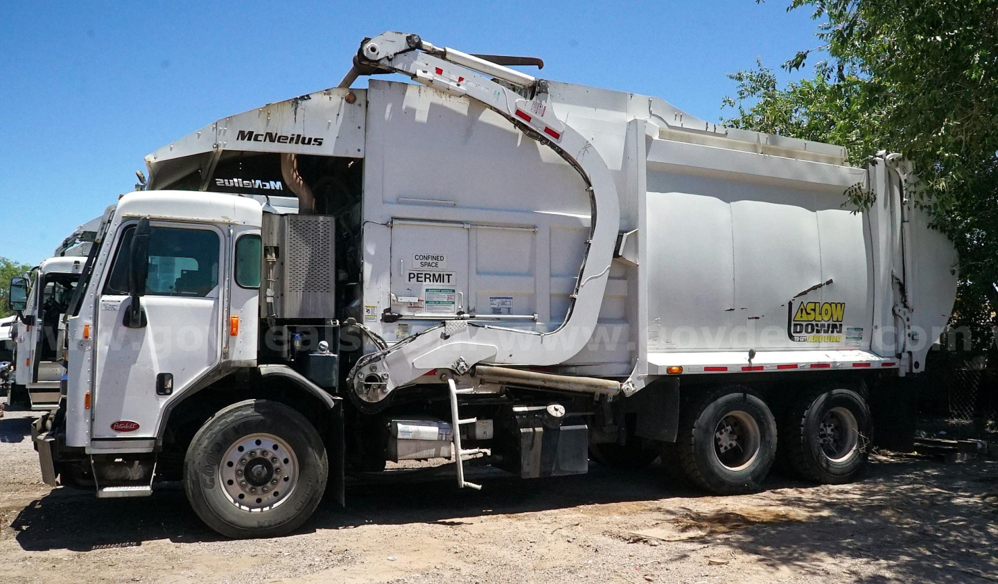 Peterbilt 320 garbage truck side view showing McNeilus body and Dareon/Dewper label with permit sticker