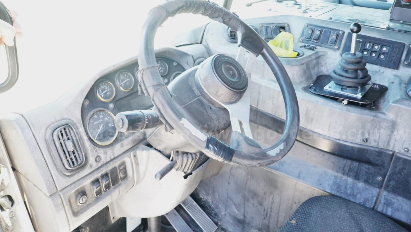 Peterbilt 320 interior showing steering wheel and dashboard with gauges and gear shift.