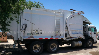 Peterbilt 320 garbage truck side view showing Ashler-style rear compactor and hydraulic arms.