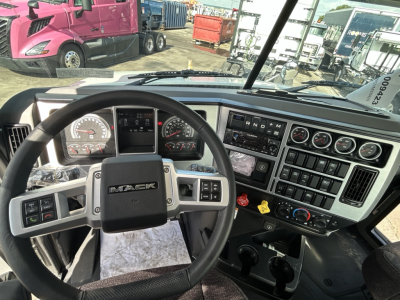 Mack GR84FT dashboard and steering wheel interior view with instrument cluster, controls, and gear shift in cab.