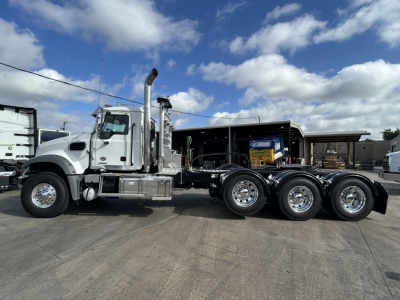 Mack GR84FT truck chassis side view showing cab, exhaust stack, and dual rear axles with polished rims.