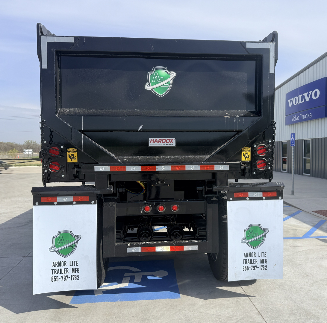 Dump trailer back view with Armor Lite logo, HarDOX label, and reflective tape. White mud flaps show Armor Lite Trailer Mfg contact; RGB lights and license area visible.