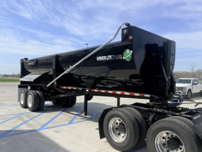 Armor Lite SHD 28/48 dump trailer in black with branding, single point hitch, dual rear axles, and front hitch stand visible.
