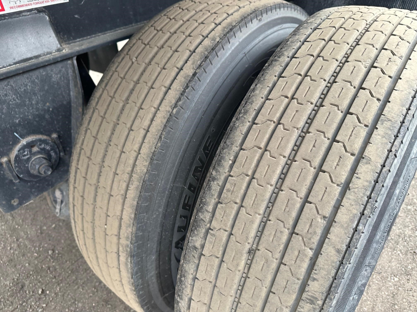 Dual rear tires of a Fontaine trailer showing tread pattern and sidewall text with bold lettering near the inner tire.