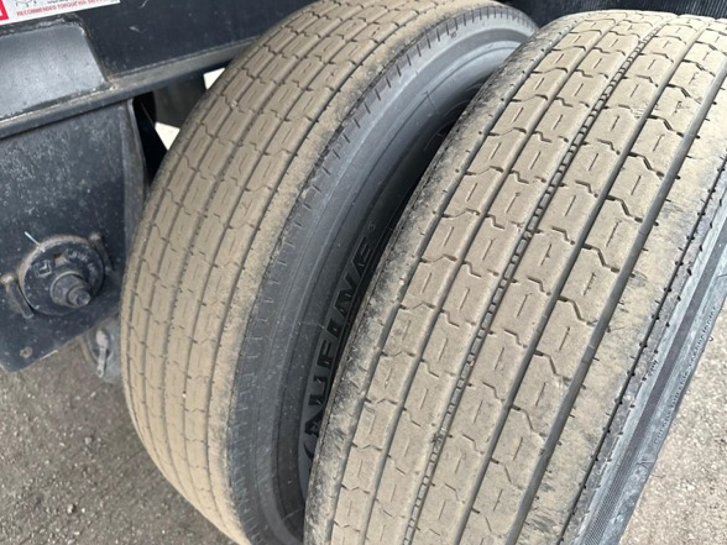 Fontaine Infinity trailer wheel and dual tires showing tread and rim; side of trailer with suspension mount visible.