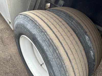 Trailer axle with dual tires on Fontaine INFINITY flatbed trailer. Visible tire tread and sidewall text shows Goodyear? and wheel rim.