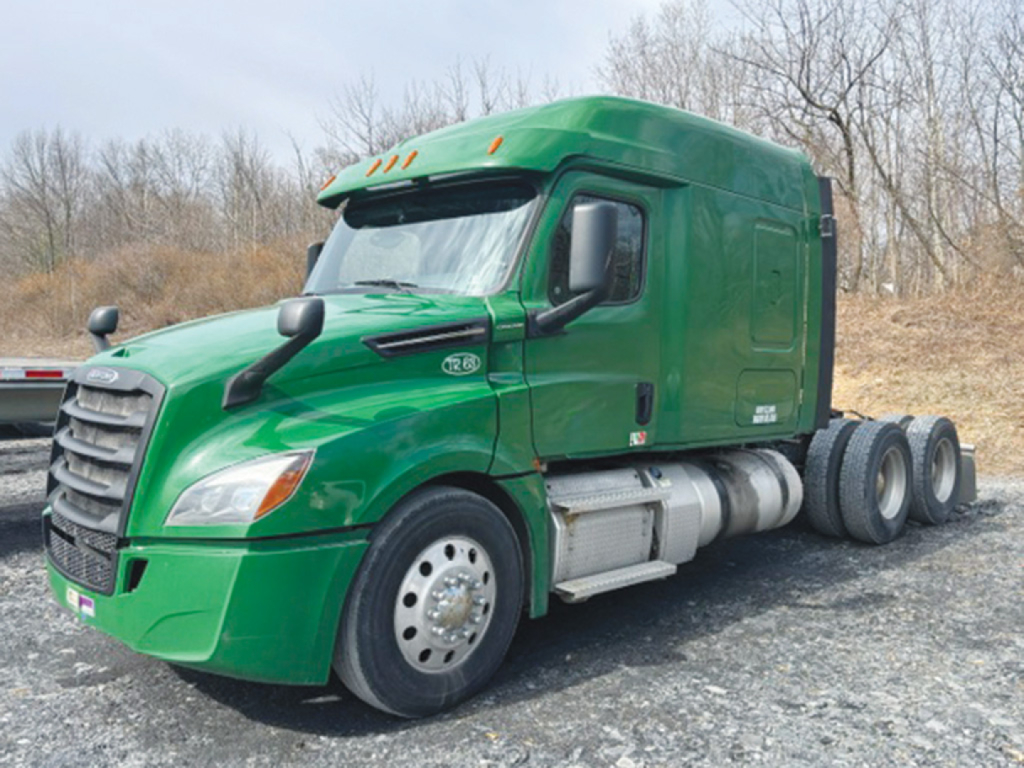 Freightliner Cascadia126 semi-truck in green color, side view showing cab and rear wheels.