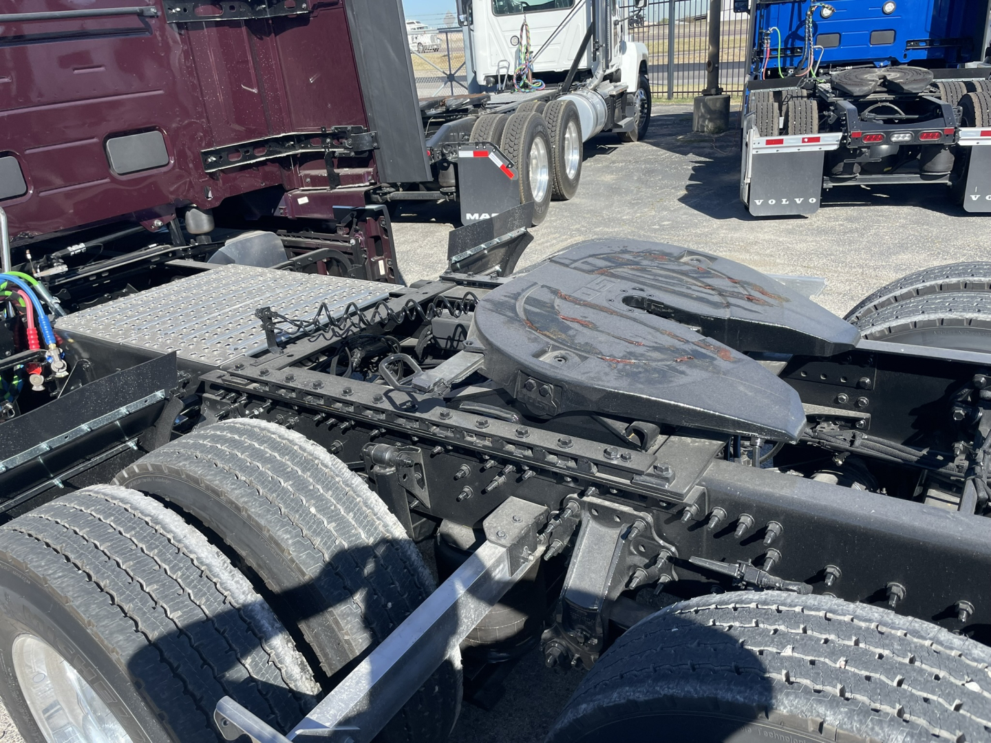 Vehicle chassis with fifth wheel and dual rear axles of a new Volvo VNL64T860 truck (no cab attached) showing a battery/infrastructure area and exposed frame rails.