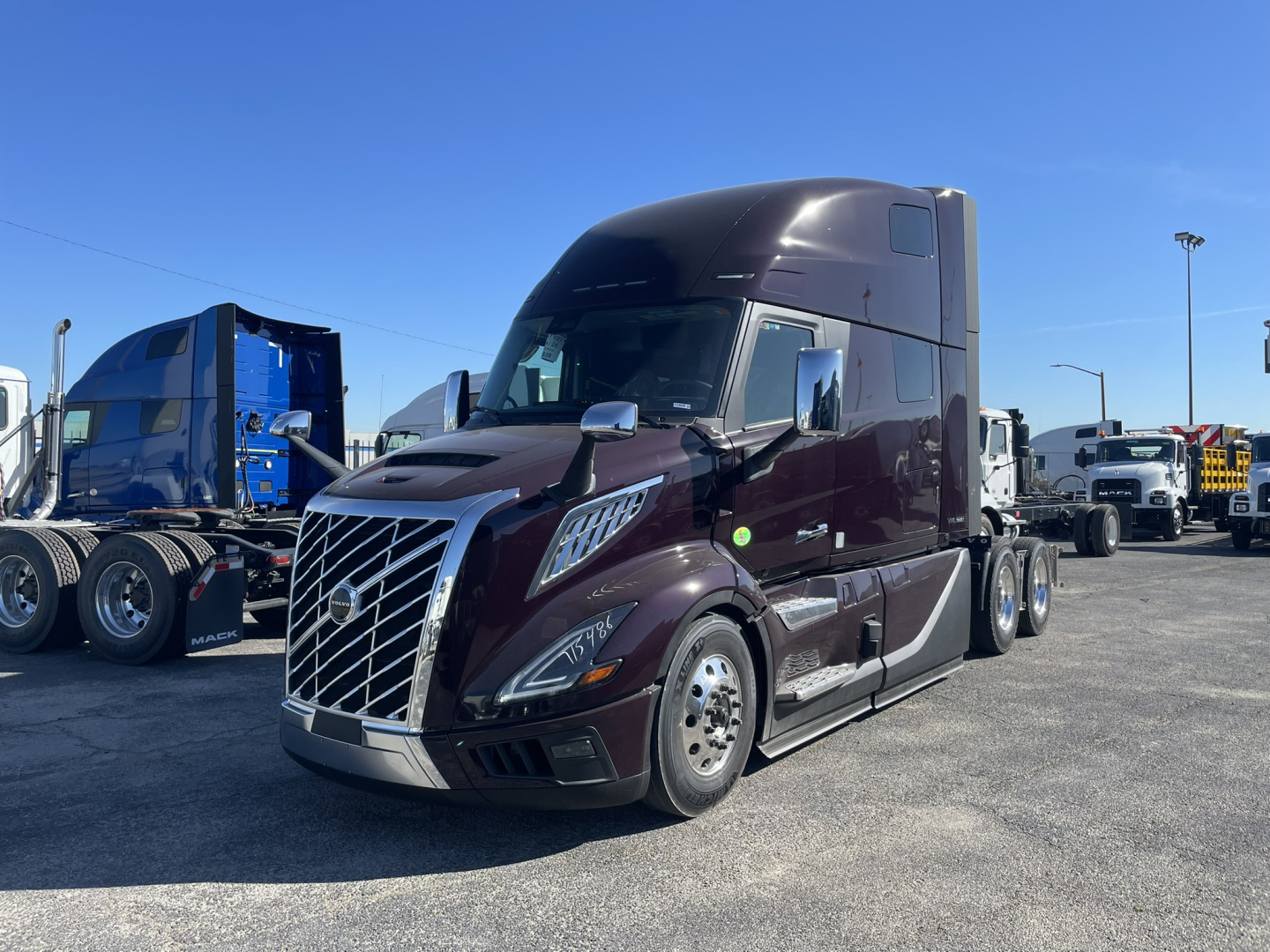 Volvo VNL64T860 tractor front-left view showing glossy burgundy paint, chrome grille, aerodynamic mirrors, and sleeper cab.