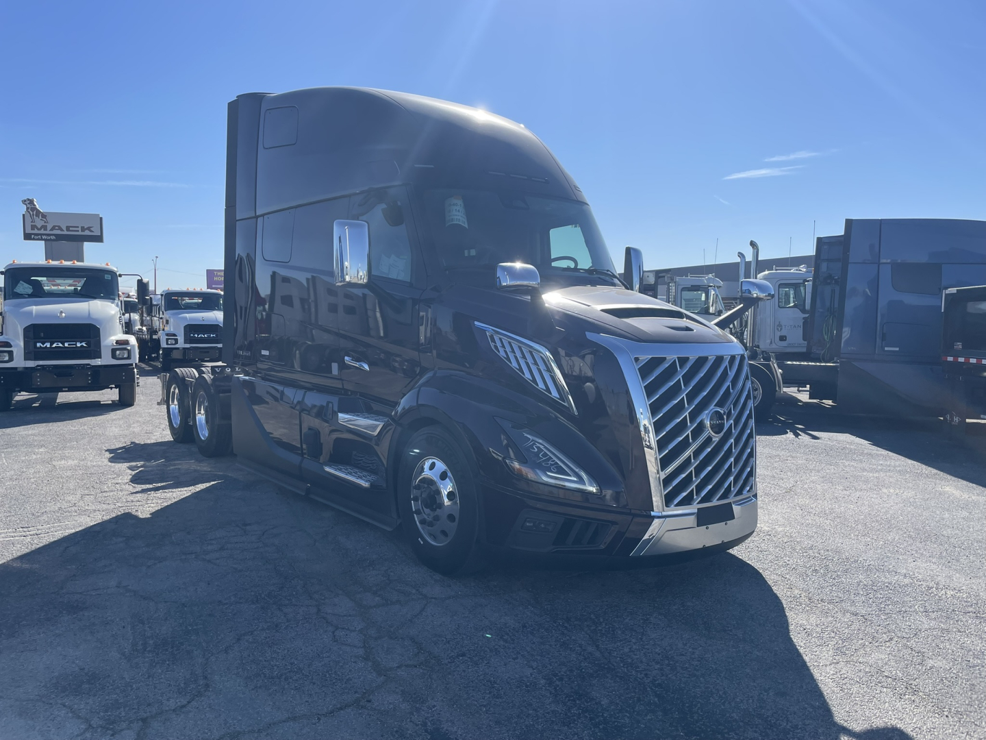 Volvo VNL64T860 truck in dealer lot, front three-quarter view showing aerodynamic cab, chrome grille, and dual rear axles under the trailer.