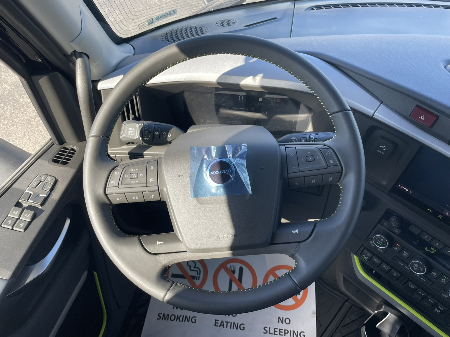 Volvo steering wheel and dashboard in a new 2026 Volvo VNL64T860. Visible text on control panels: no legible model text, dashboard buttons and a sticker on the steering wheel.