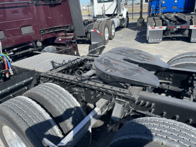 Vehicle chassis with fifth wheel and dual rear axles of a new Volvo VNL64T860 truck (no cab attached) showing a battery/infrastructure area and exposed frame rails.