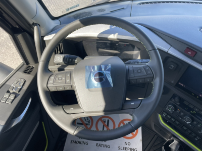Volvo steering wheel and dashboard in a new 2026 Volvo VNL64T860. Visible text on control panels: no legible model text, dashboard buttons and a sticker on the steering wheel.