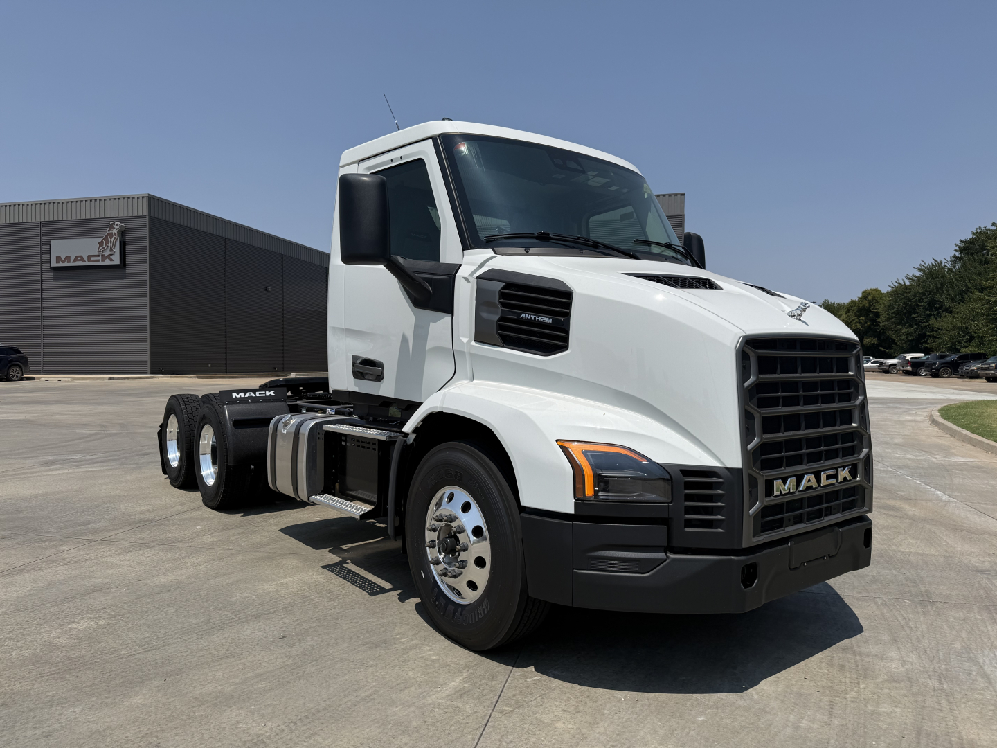 Mack AN64T conventional daycab truck in white, front three-quarter view, with black grille and large side mirrors.