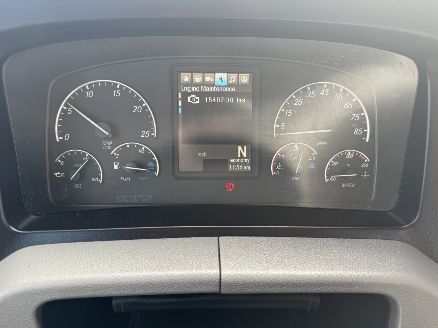Dashboard of a Freightliner PT126064S T showing instrument cluster and central display with engine maintenance label; visible text includes Engine Maintenance 15407:30 hrs, rpm gauge, mph gauge, N gear indicator, time 11:56 am, and various