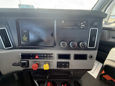 Dashboard of Freightliner PT126064S T truck showing dashboard controls, switches, and gauges with warning lights and two colored knobs.